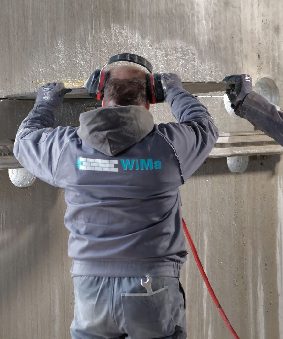 Handwerker in Schutzkleidung nutzt eine Schleifmaschine an einer Metalloberfläche.